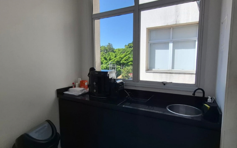 Copa por andar do Trampô Space, com cafeteira e pia, vista para as árvores.
