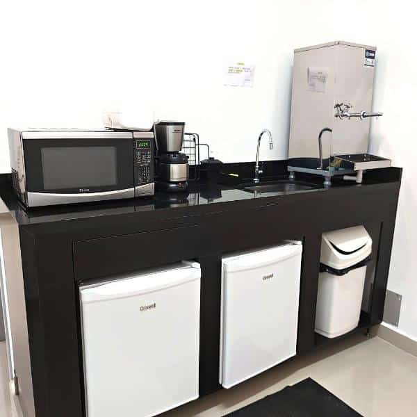 Copa compartilhada do Trampô Space, com micro-ondas, cafeteira, pia e frigobares.