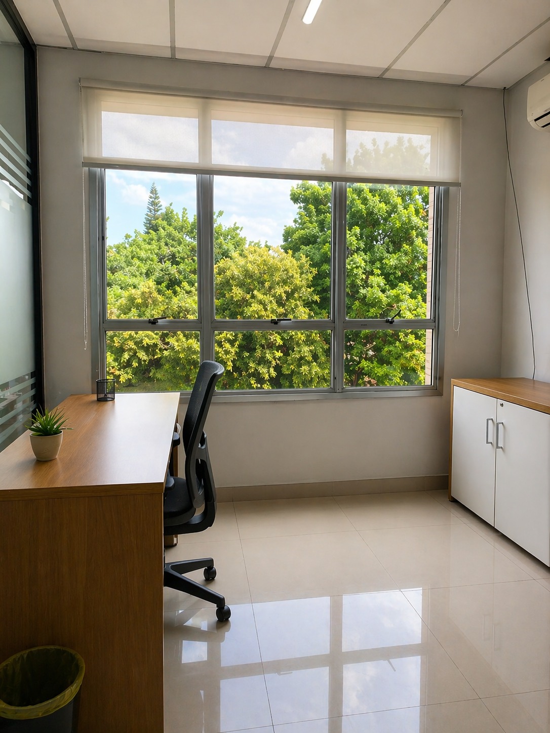 Sala privativa Safira do Trampô Space, mesa individual com planta e vista para árvores.